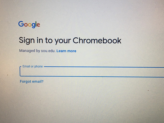 Picture of the google sign in page with emphasis on the managed by sou label located under the prompt to sign into your chromebook but over the field in which one is being prompted to place their email or phone number into. There is also a learn more hyperlink next to the managed by sou.edu label.